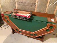 Games table folded upright with game boxes on top