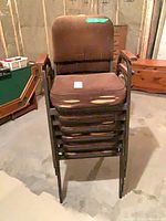 Stack of six brown upholstered armchairs
