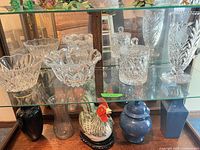 All four cut glass pieces displayed on glass shelf