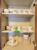 Cabinet shelves with cups, saucers, plates and creamers