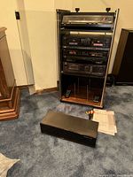 Rack open showing all JVC components, remotes, cables, manual, CD holder