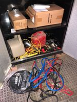 Cabinet with fuel cans, power tool, cords, boxes
