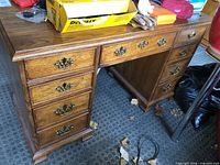 Overall view of oak kneehole desk showing drawers and hardware