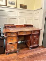 Front view of desk showing twin pedestals, upper drawers, leather inset