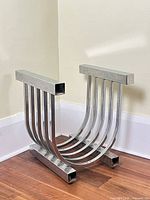 Front angled view of chrome U-shaped table base showing curved slats and rectangular rails