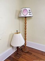 Both lamps side-by-side showing relative size, wood columns, shades, clear bases