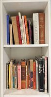 Shelf with two rows of assorted cookbooks
