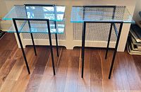 Two modernist steel and glass side tables front view
