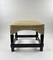 Front view of oak stool showing cream vinyl seat and dark wood frame