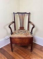 Front view of the armchair showing full structure, upholstery and wear