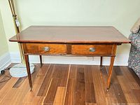 Front view of mahogany writing desk showing drawers and leg structure