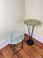 Two side tables together showing relative sizes, materials and bases