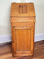 Front view of antique pine lectern desk showing sloped top and cabinet door
