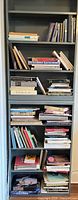 Tall bookcase filled with multiple shelves of art books