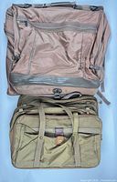 Both bags laid flat, Skyway brown bag on top, Hartmann green bag below