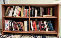 Low mahogany-finish bookcase filled with books