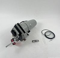 Enlarger head with attached focusing tube, negative stage, red filter, shown with diffuser disc and cable release.