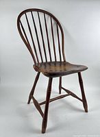 Three-quarter front view of Windsor chair showing bow back, seat and legs
