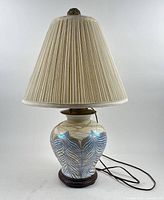 Full view of porcelain vase table lamp with shade and cord