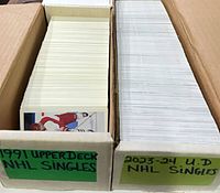 Two long boxes filled with hockey cards labeled for 1991 and 2023-24