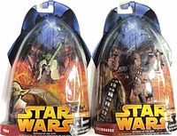 Front view of both sealed figures, showing packaging and accessories