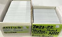 Two open storage boxes filled with hockey cards, labels visible