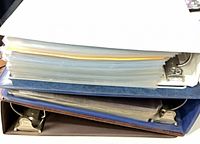Stacked view of three binders showing ring mechanism and thickness of filled pages