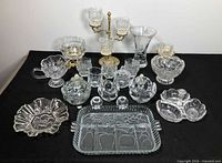 Full lot overview of assorted crystal and glass items on table
