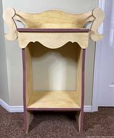 Front view of painted accent stand showing open shelf and scalloped apron