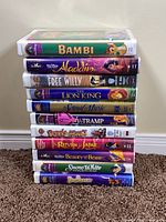 Stack of all visible VHS tapes showing titles and clamshell cases