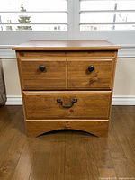 Front view of nightstand showing drawer arrangement and hardware