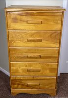 Front view showing five drawers and wood pulls