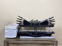 Full set showing grill, pans, spatulas, and stacked plates