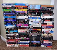 Full view of eight stacks of VHS tapes showing quantity and variety