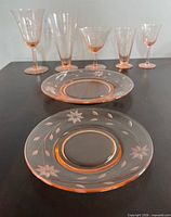 Stemware and plates showing etched floral pattern