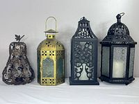 Four lanterns side by side on table