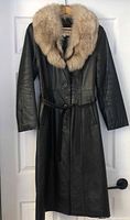 Full view front of black leather coat with fox fur collar and belt