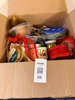 Open cardboard box filled with assorted ribbon spools