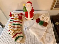 All items on tabletop: Santa cookie jar, two striped stockings, one cream stocking