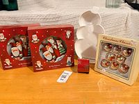 All items grouped: two plate sets, ornament set, ribbon roll, snowman dish
