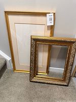 Both gold picture frames side by side for size comparison