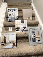 Five hardcover interior design books displayed on stairs