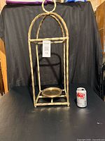 Full frontal view showing entire candle holder beside soda can for scale