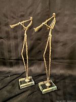 Front view of both metal musician statues on glass bases