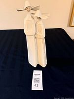 Full front view of Lladro nun sculpture on dark surface