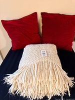 Throw blanket and two red pillows grouped