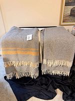 Both grey throw blankets displayed over furniture