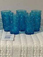 Group of eight blue textured juice glasses displayed together