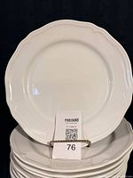 stack of large white scalloped dinner plates