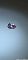 Emerald-cut pink kunzite angled under light